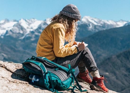 Girl journaling on a mountain