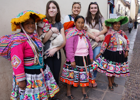 Girls holding lambs in Peru