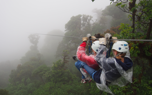 Two students doubled up on a zipline