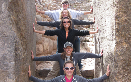 Students with hands on stone walls