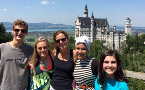 5 students with Neuschwanstein castle in distance