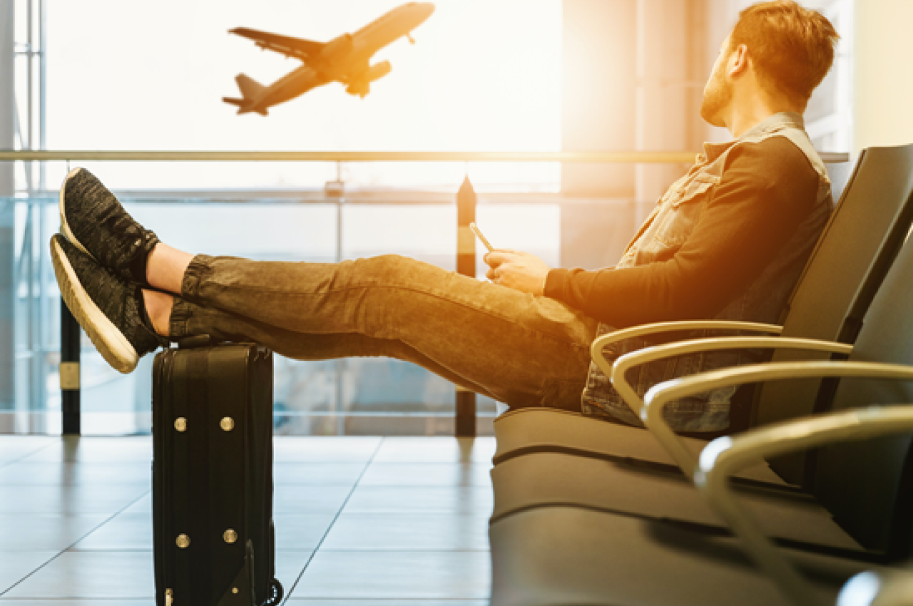 Boy in airport watching a plane take off